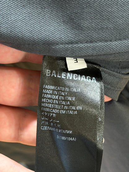 Balenciaga label on a garment held by a hand