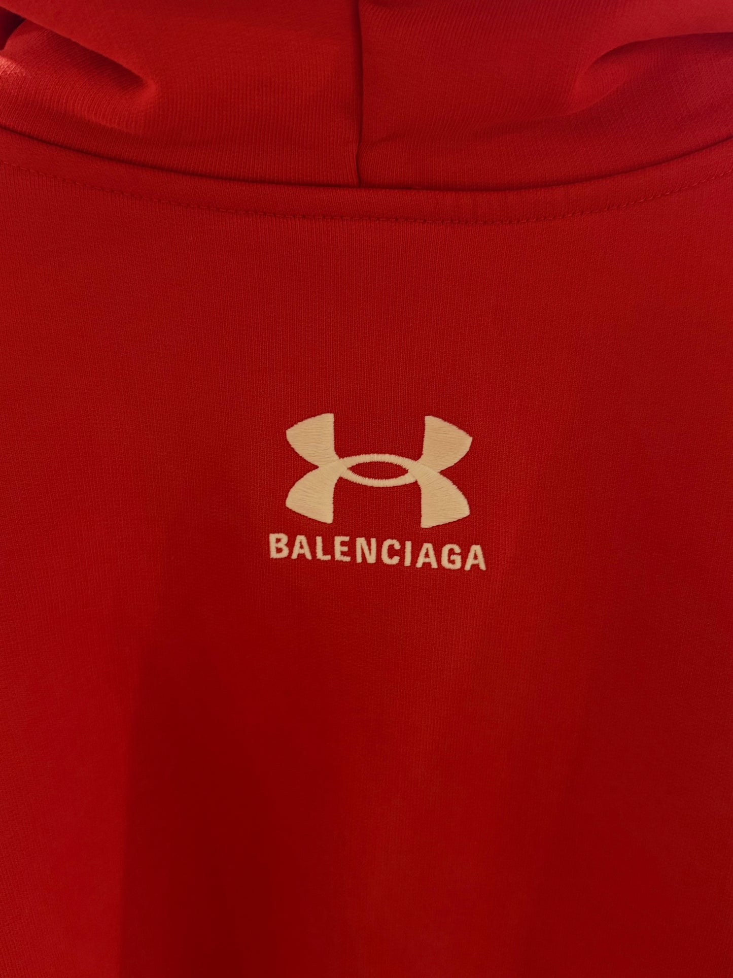 Red hoodie with Balenciaga logo on a plain background